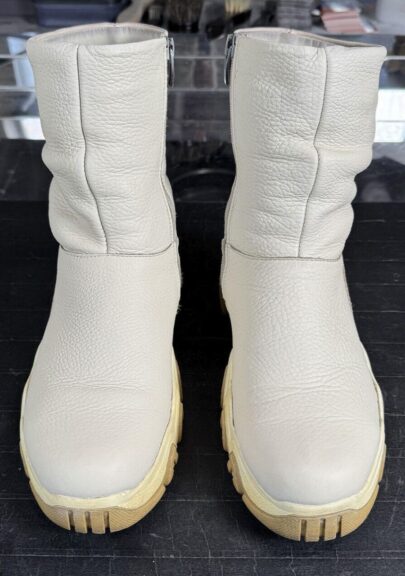 Белые кожаные сапоги с тёмными пятнами после чистки в цеху Дулито